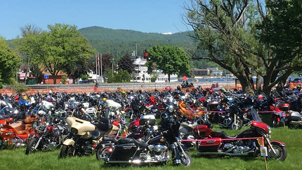 Motorcycles stand on a large green lawn in Lake George for the Americade motorcycle touring rally.