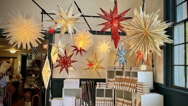 colorful hanging paper stars dangle above a shop display