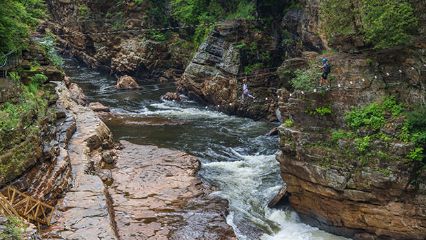 A person walking across a bridge in the Ausable Chasm