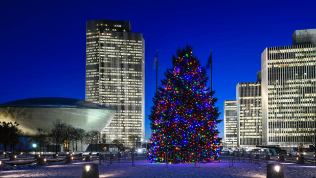 Winter shot of the ice rink at empire state plaza with views of the Christmas tree, the Egg, and Corning Tower lit up against a dark blue sky