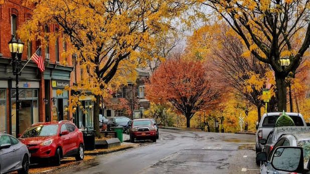 Street view of orange and red trees surrounding shops in Beacon, NY