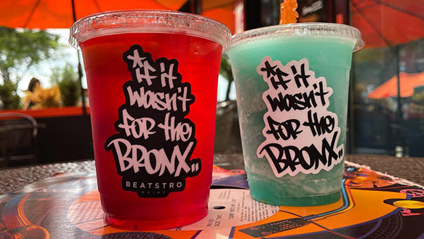 A blue drink and a red drink in plastic cups that read "If it wasn't for the Bronx" at Beatstro