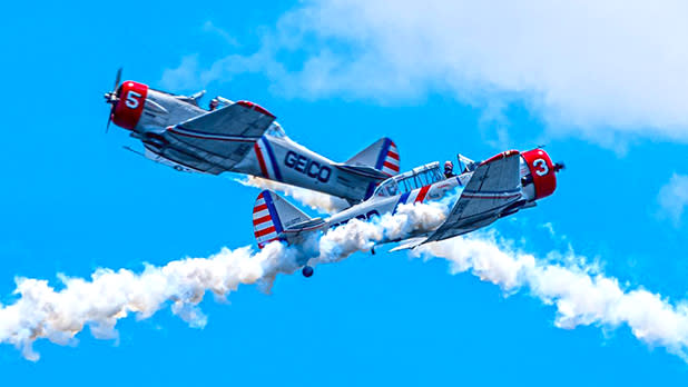 Two planes fly across each other in the clear blue sky as part of the Bethpage Air Show