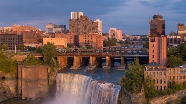 Rochester's High Falls surrounded by the city at sunset