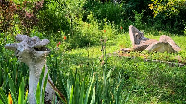 Two sculptures surrounded by vibrant green vegetation