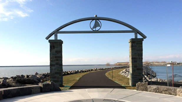 Exterior of archway over a walking path surrounded by the waters from Buffalo Harbor State Park on a sunny day