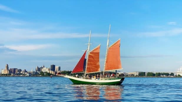 The Spirit of Buffalo sailboat with red sails floating on Lake Erie