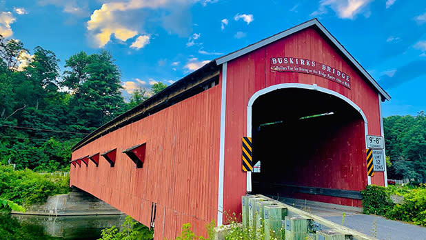 The rich red barn-like facade of the 1857-built Buskirk Covered Bridge, one of just three in New York State sporting the classic Howe truss design