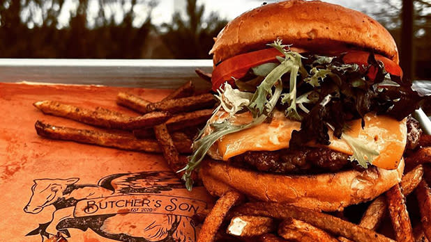 A well done cheeseburger and french fries on butchers paper