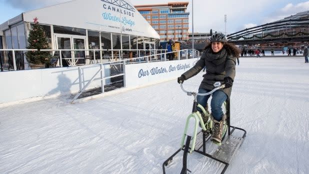 A woman rides an ice bike at Canalside