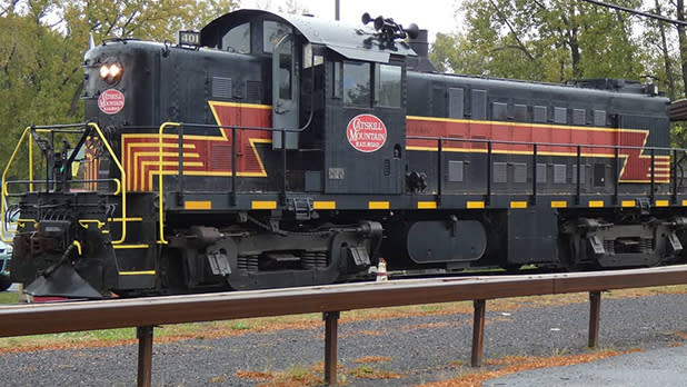 A black, red, and gold trim train on the tracks along the Catskill Mountain Railroad
