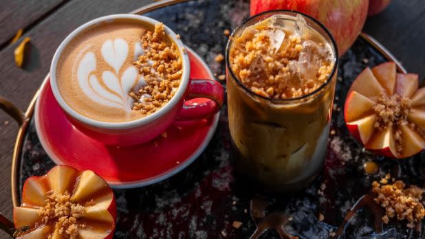 Cold and hot lattes surrounded by autumnal apple decor