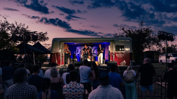 Band performing at sunset in front of crowd
