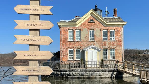 lighthouse with directional sign in front