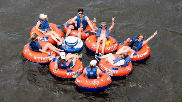 People in bright red tubes floating in a river