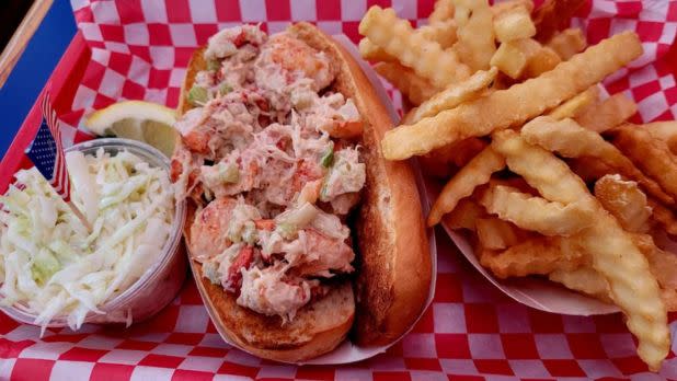 lobster roll next to cole slaw and fries