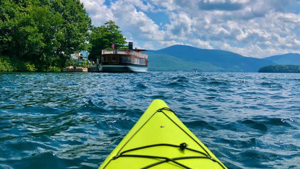 Kayak on Lake George with a boat and mountains in the background