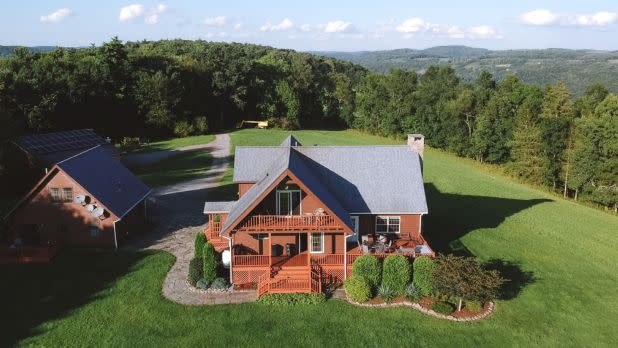 Rustic mountain house on grassy landscape with trees