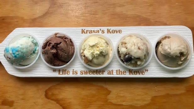 Ice cream flight featuring five small bowls of ice cream with "Krasa's Kove" written on the top and "Life is sweeter at the Kove" written on the bottom