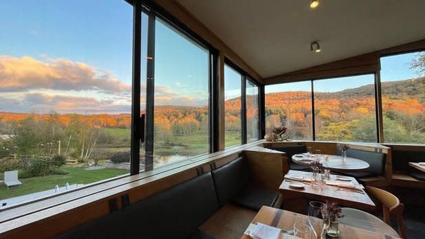 view of the sun shining on the mountains from the dining room at The DeBruce in the Catskills
