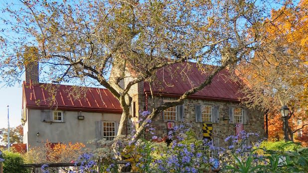Exterior of the Old Stone House Historic Interpretive Center in spring, surrounded by flowers and vegetation