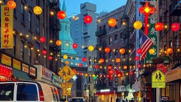 Yellow, orange and red lantern string lights draped across the street in Chinatown