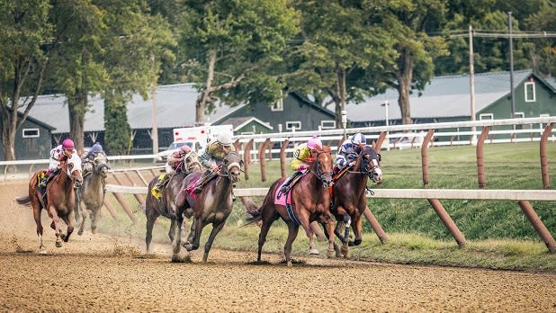 Five horses and jockeys race to the finished line at the Saratoga Race Course