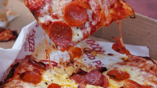 A slice of cheesy pizza with cup-and-char pepperoni