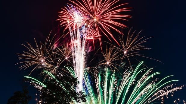 Green, red, and gold fireworks bursting in the night sky