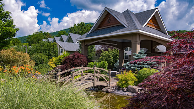 Small bridge over a stream leading to a wood gazebo at Emerson Resort & Spa