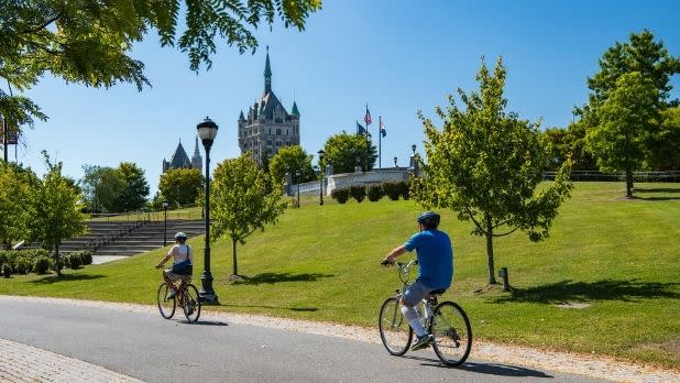 Two people ride bikes on the Empire State Trail at the Corning Preserve