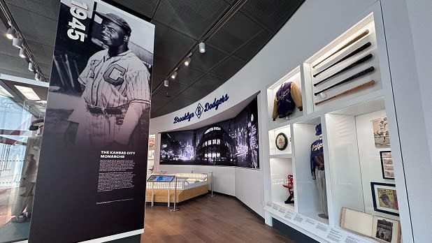 An exhibit showcasing various artifacts including a Brooklyn Dodgers uniform at the Jackie Robinson Museum