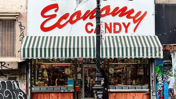 A storefront with a green and white awning with a sign reading Economy Candy