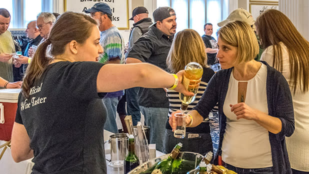 A woman pours a drink for a guest at the Glens Falls Brewfest