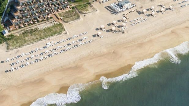 aerial view of the private oceanfront beach, lawn chairs, and property at Gurney's Montauk Resort