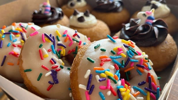 Donuts with vanilla icing and rainbow sprinkles, chocolate icing and unicorn design, and vanilla icing with chocolate chips