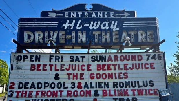 Retro sign the reads "Entrance Hi-Way Drive-In Theatre" and current showings