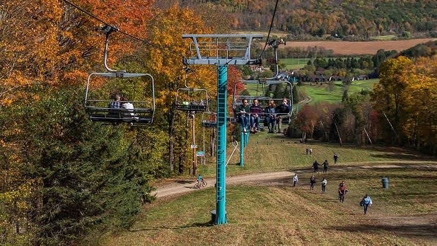 People take in the fall foliage sights on a chairlift ride at Holiday Valley Resort