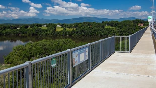 A pedestrian/bicycling path on a bridge with a view of the Catskill Mountains