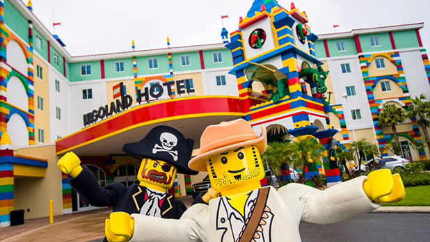 A pirate and another Lego figure in front of Legoland Hotel