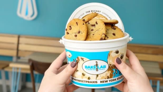 A bucket labeled "Bake Lab" filled with chocolate chip cookies.