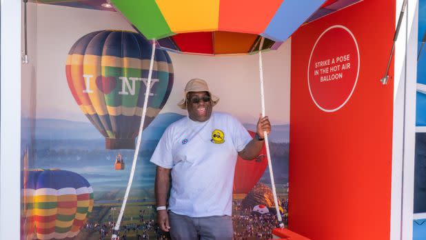 A person poses in a hot air balloon basket at the I LOVE NY Experience