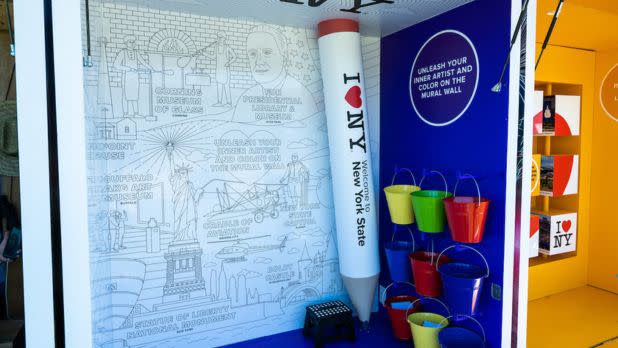 A giant coloring page with a mural of New York art and cultural attractions at the I LOVE NY Experience