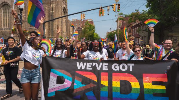 People march in the Capital Pride Parade and Festival holding a sign that reads "We've Got Pride"