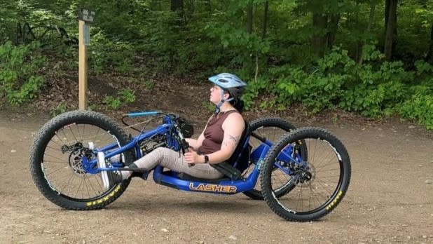 Tara sitting in an adaptive mountain bike