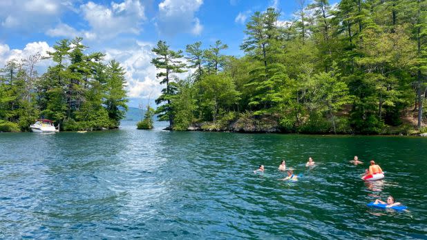 People swimming in Lake George with island in background