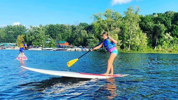 A person using a stand up paddle board on the lake.