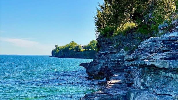 Bright blue waters at Robert G. Whele State Park against gret limestone cliffs
