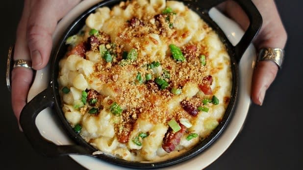A creamy bowl of macaroni and cheese served in a personal cast iron dish topped with crunchy bread crumbs