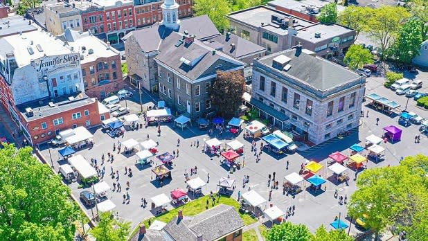 Aerial view of people walking in between tents and various buildings